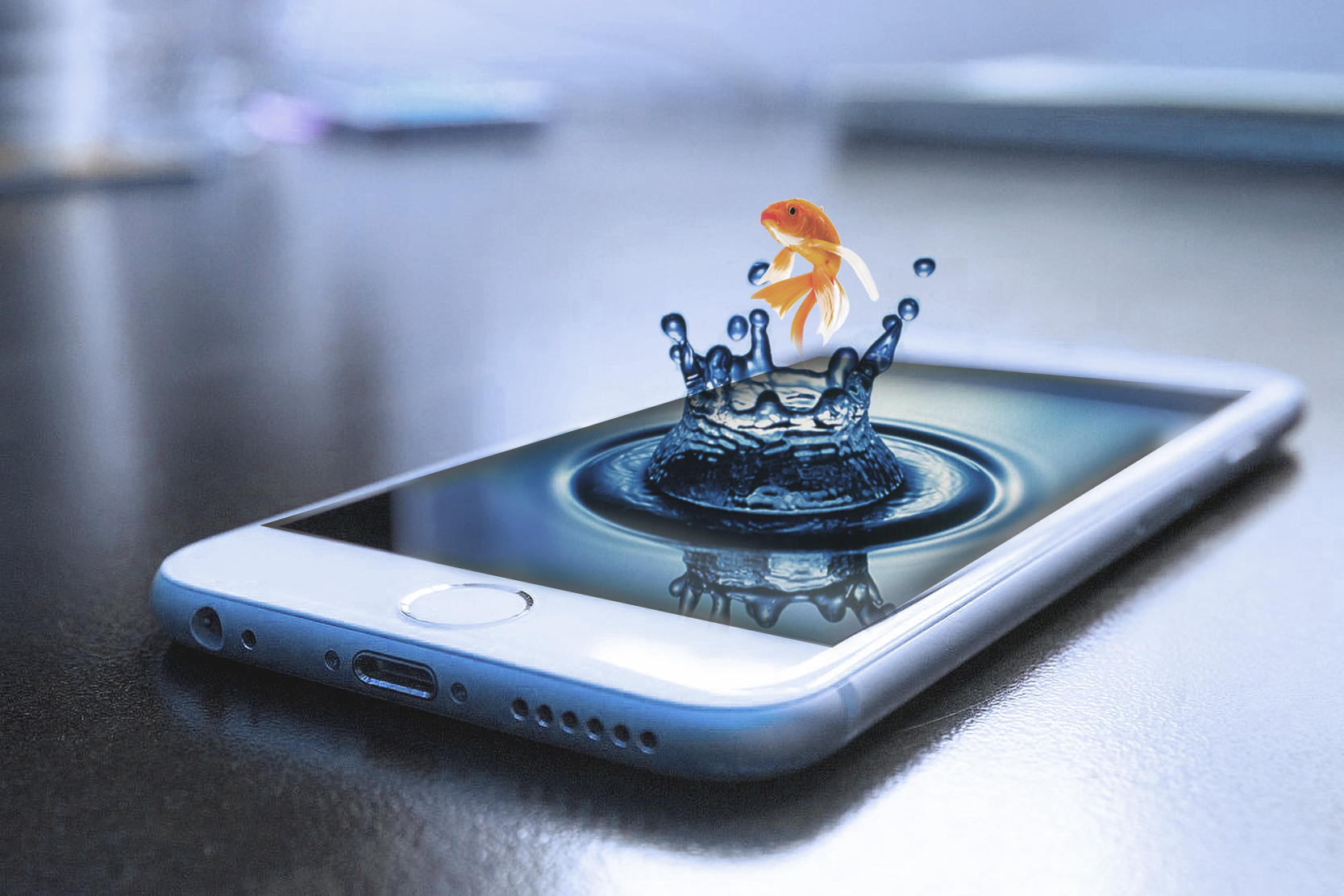 Mobile gold fish splash. Image of a a gold fisg splashing out of a phone screen like it water